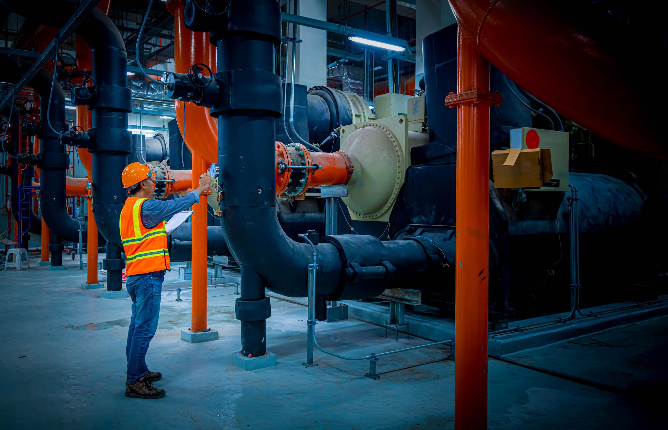 engineer under checking the industry cooling tower air conditioner is water cooling tower air chiller HVAC of large industrial building to control air system.